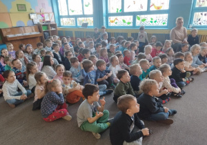 dzieci siedzą na dywanie