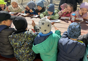 dzieci jedzą kiełbaskę