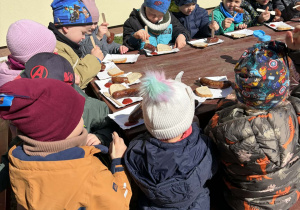 dzieci jedza kiełbaski